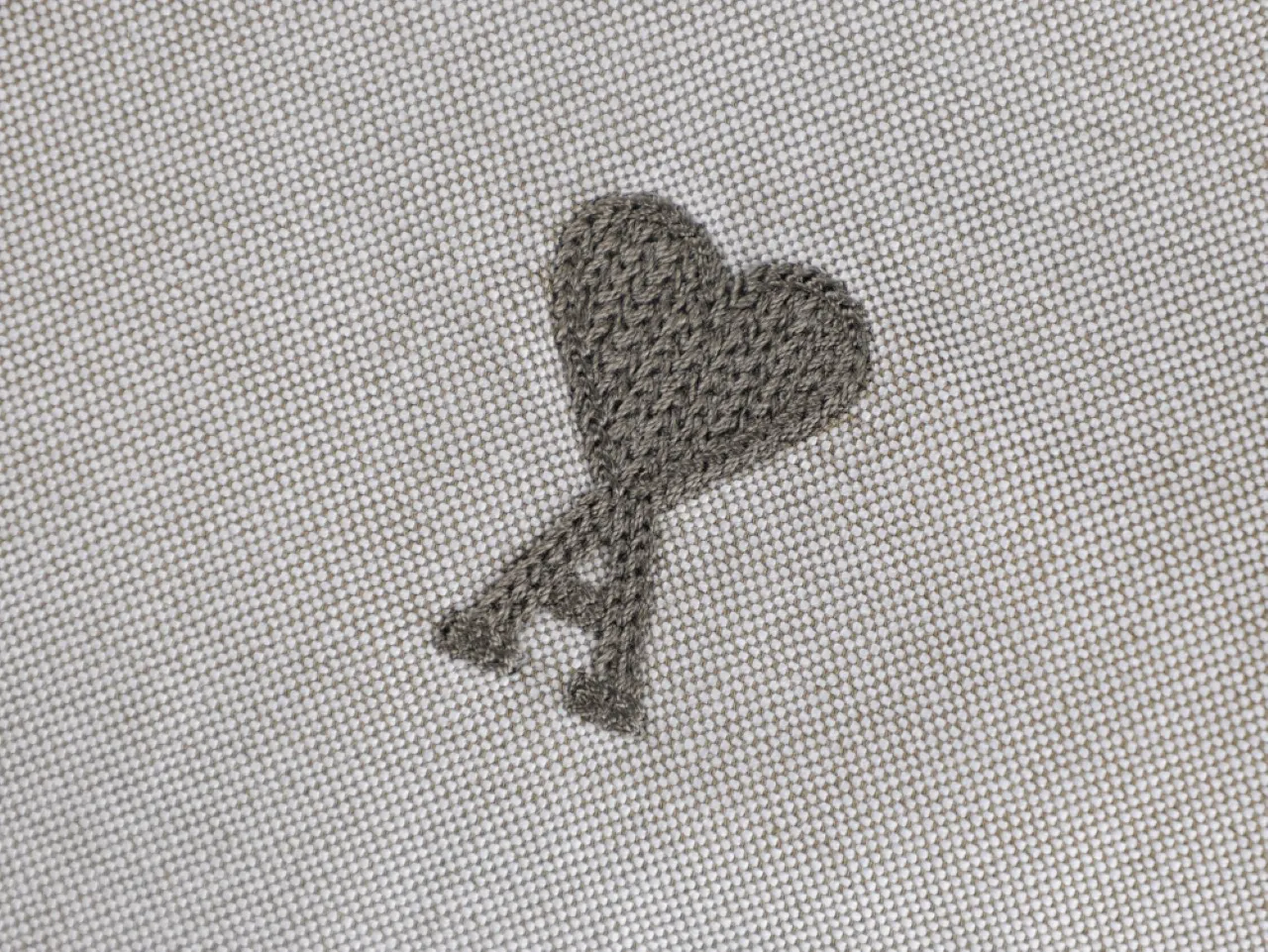 Embroidered heart on beige fabric background