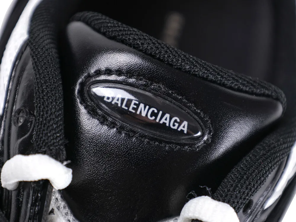 Black leather shoe tongue with black laces, featuring white stitching detail.