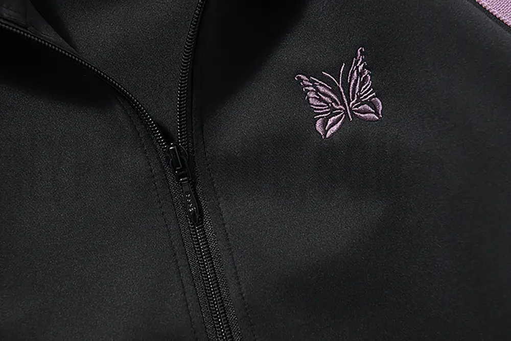 Close-up of butterfly embroidery detail on the chest of the jacket.