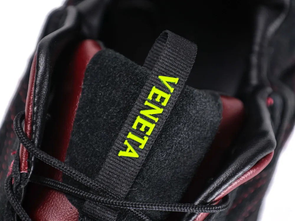 Black and red fabric sneaker tongue with "VENETA" label in bold yellow.