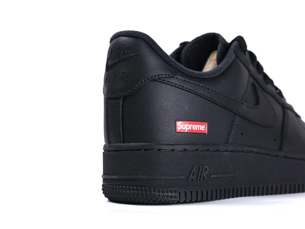Black leather sneaker with embossed logo and distinctive red tag on the heel.