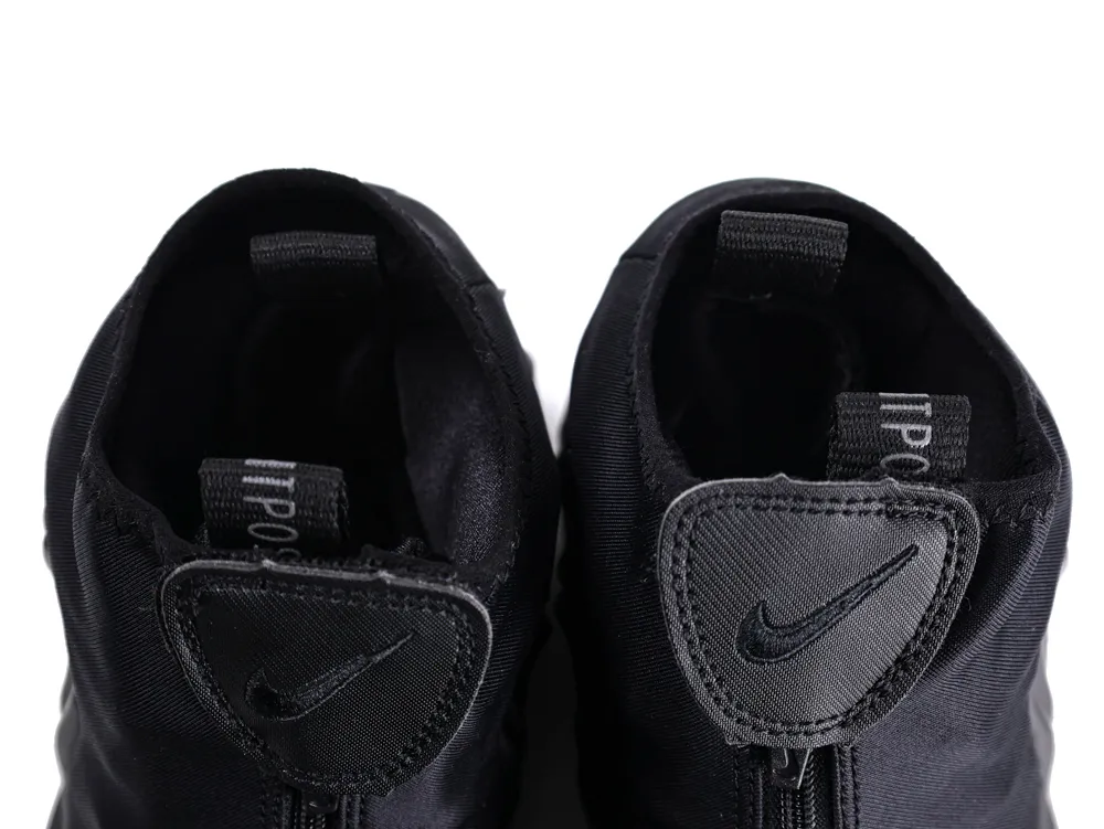 Close-up of black fabric shoe tongues with logos and pull tabs.