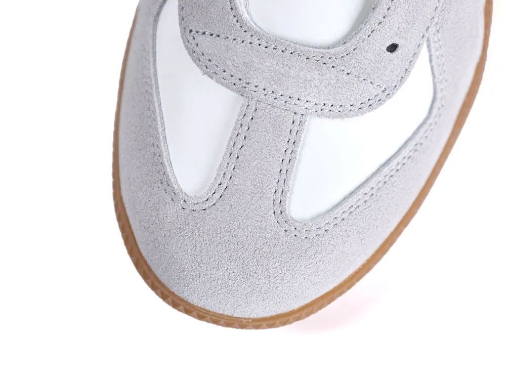Gray suede shoe with brown sole and white insole, showing stitched upper part.