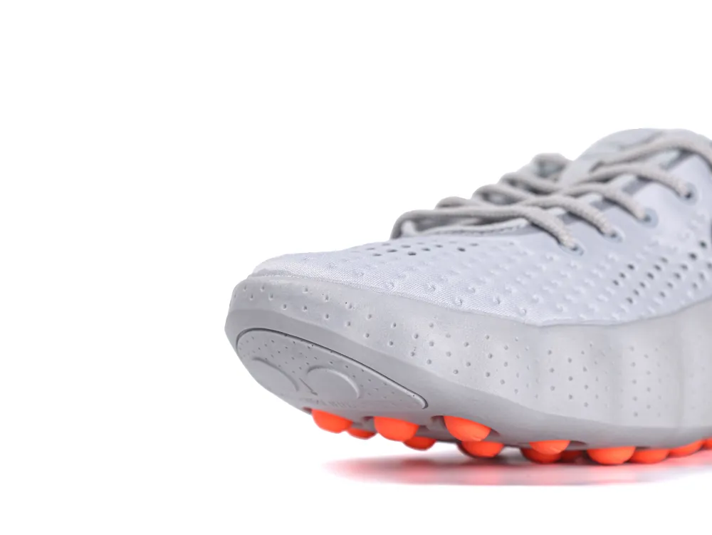 Gray perforated sneaker with orange rubber sole, highlighting its lace-up design.