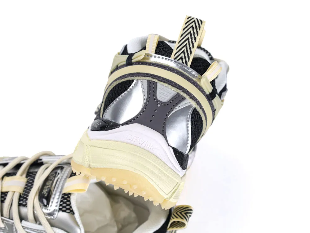 Silver and beige sneaker with black mesh, featuring a textured rubber sole.