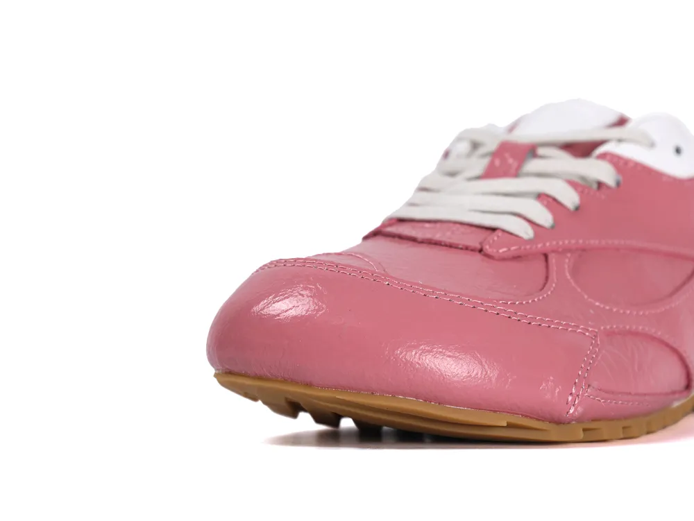 Close-up of the rounded toe and white laces on pink leather Orbit Flash sneakers.
