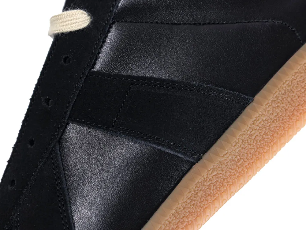 Black leather and suede sneaker upper with beige rubber sole detail.