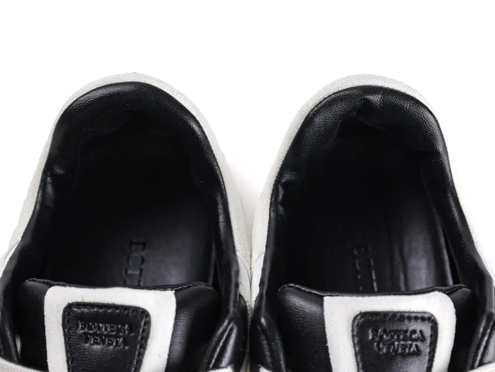 Black and white leather sneaker interiors, featuring brand detailing on the tongue.