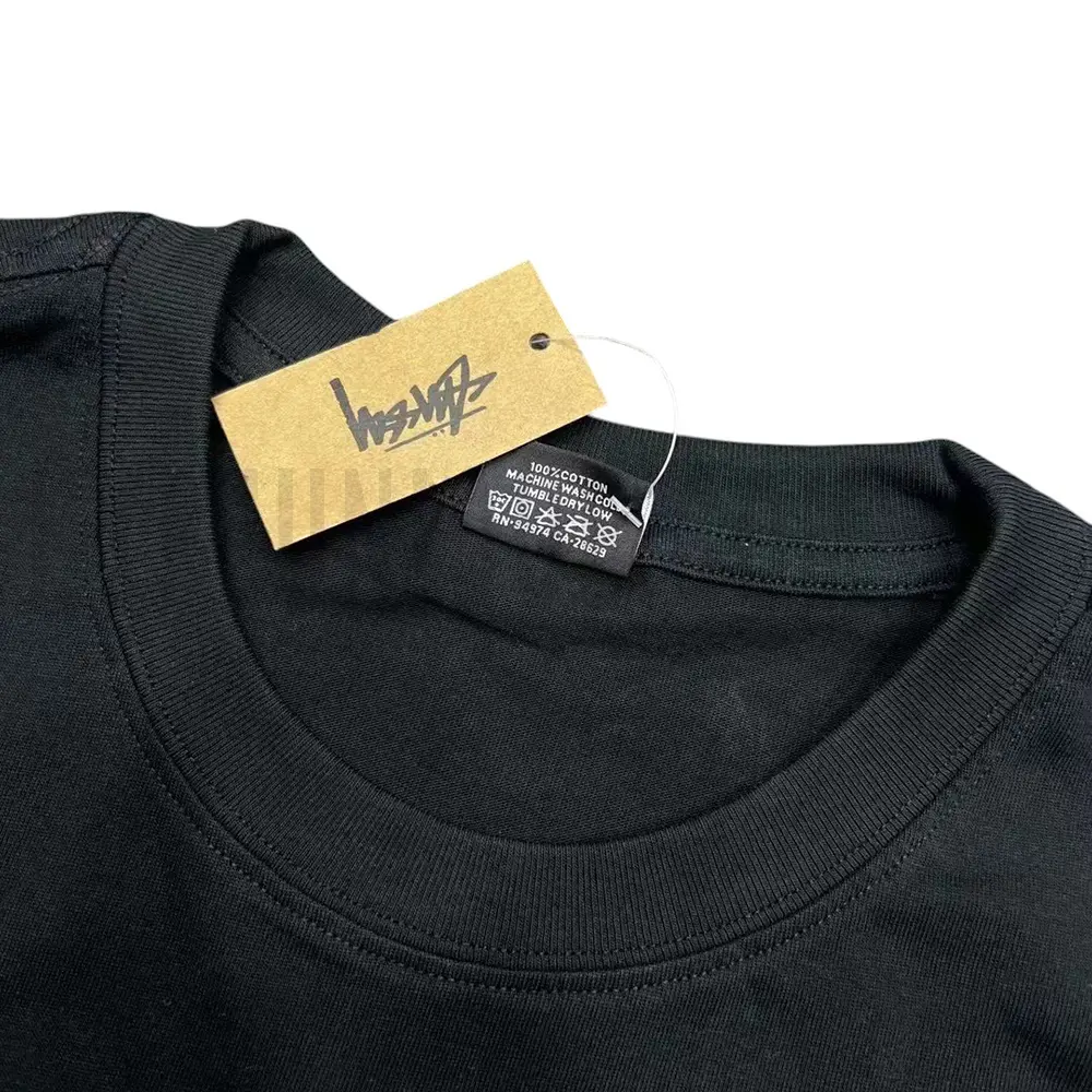 Neckline tag close-up, displaying garment care symbols and brand information with fashion-forward presentation.