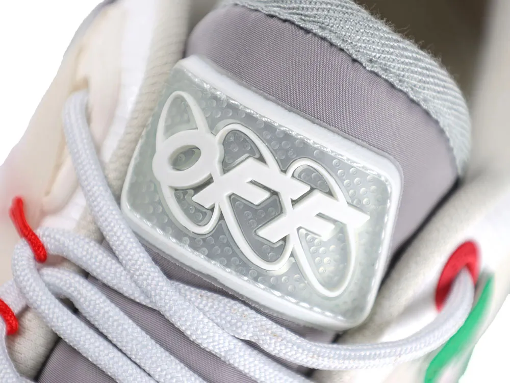 White and gray sneaker tongue with rubber logo and red lace accent.
