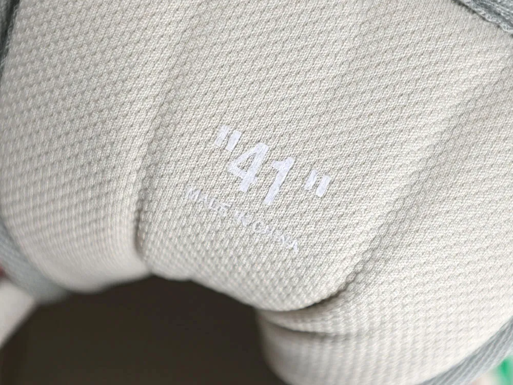 Gray woven fabric shoe detail with "41" number printed in white.