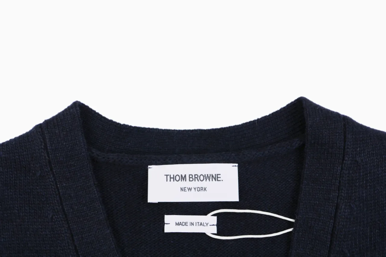 Thom Browne New York label and Made in Italy tag on navy knit cardigan.